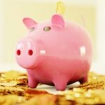 How much should I save per month illustrated with a pink piggy bank, symbolizing savings strategies, average saving per month, and best ways to grow IRAs.