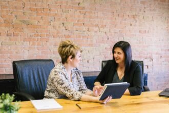 Two women in a professional meeting discussing financial planning, representing Edward Jones Wealth Management services.