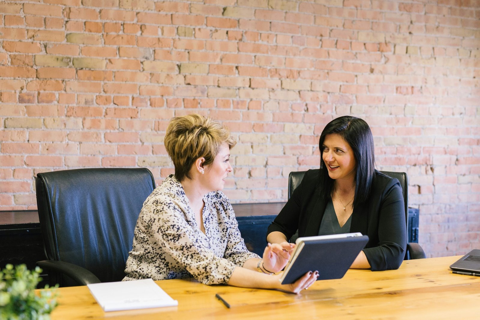 Two women in a professional meeting discussing financial planning, representing Edward Jones Wealth Management services.
